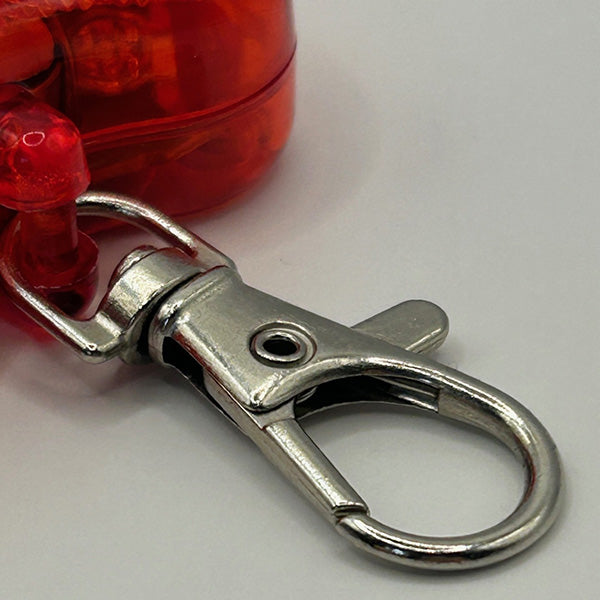 Metallic keychain clip attached to a red dog flasher on a white background