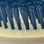 Close-up of a brush with black bristles on a beige base