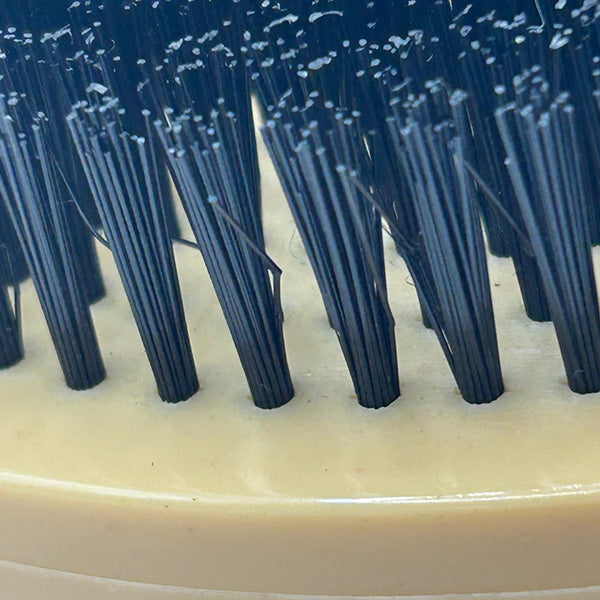 Close-up of a brush with black bristles on a beige base