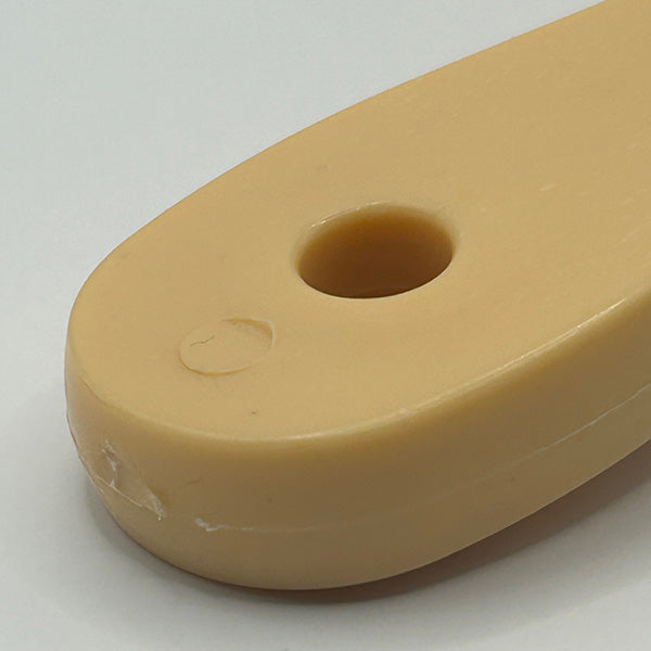 Beige plastic handle with a hole on a white background