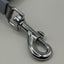 Metallic dog leash attachment on a gray background