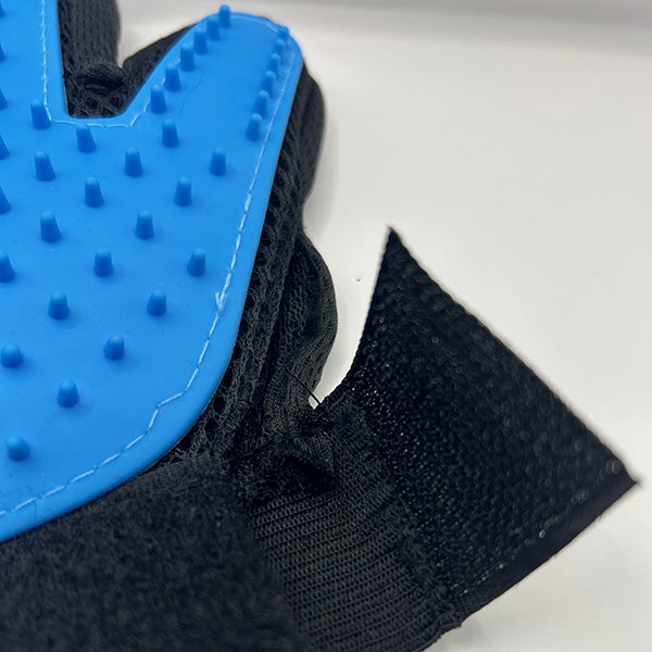 Dog grooming glove close up of details including stitching and black Velcro strap on white background
