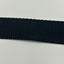 Close-up of a black woven seat belt strap on a light grey background