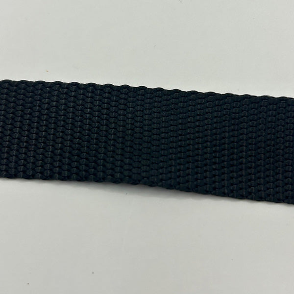 Close-up of a black woven seat belt strap on a light grey background