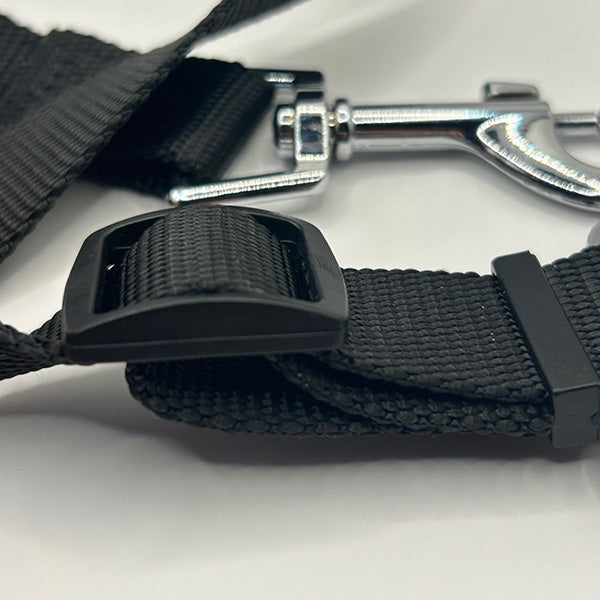 Close-up of a black strap adjustment with a metal clip on a white background