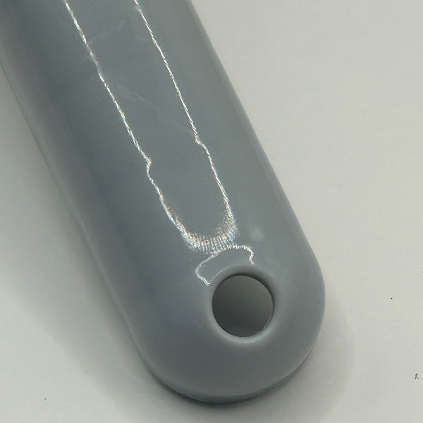 Close-up of a grey scoop handle with a circular hole on a white background