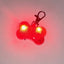 Red bone-shaped LED light with a clip on a gray background